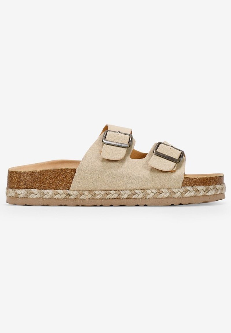 Sandalias de ante beige con tiras ajustables y hebillas metálicas, suela de corcho y detalles de yute trenzado alrededor de la Base.