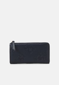 Portafoglio in pelle blu navy con motivi geometrici in rilievo, texture liscia, chiusura con zip e un sottile logo sul lato.