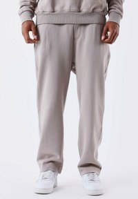 Grijze joggingsbroek gemaakt van een zachte katoenmix, met een elastische tailleband, zijzakken en een ontspannen pasvorm, gecombineerd met witte sneakers.