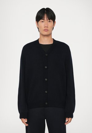 Navy knitted cardigan with a V-neck, ribbed cuffs and hem, featuring six large black buttons down the front. Simple, relaxed fit.