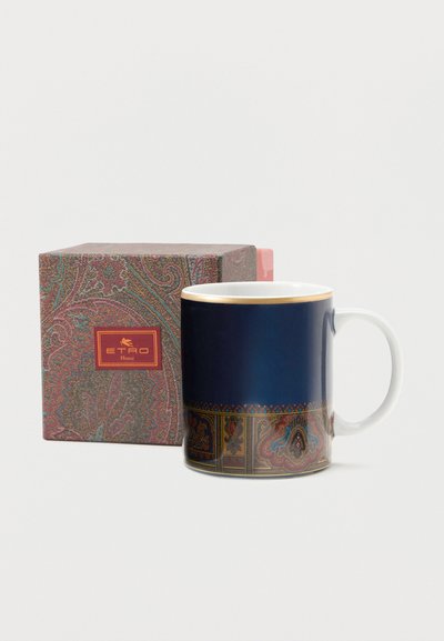 Tasse en céramique avec un motif cachemire bleu et or orné, à côté d'une boîte assortie au motif cachemire avec une étiquette rouge ETRO Home.