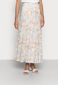 Floral maxi rok met meerkleurige patronen in oranje, paars en pastel op een lichte achtergrond. Elastische tailleband; gelaagd ontwerp.