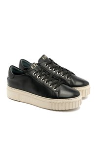 Baskets en cuir noir à bout rond, dotées d'œillets argentés, de lacets noirs et d'une semelle épaisse en caoutchouc de couleur crème. Logo de la marque sur la languette.