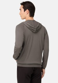 Šedá mikina s kapucňou, voľného strihu, s rebrovanými manžetami a lemom, s mäkkou textúrou a kapucňou. Minimalistický dizajn bez viditeľných log.