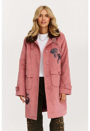 Różowy płaszcz z korduroy z sztucznym futerkiem przy kołnierzu, z dużymi guzikami, dwiema przednimi kieszeniami oraz haftami meduzy i jabłka.