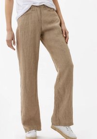Pantalon large en lin de couleur marron clair, avec une finition texturée, un design classique à cinq poches et une taille mi-haute.