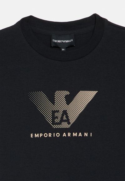 Μαύρο βαμβακερό μπλουζάκι με χρυσό πουα λογότυπο αετού και τα κείμενα "EA" και "Emporio Armani" από κάτω. Σχεδιασμός με στρογγυλή λαιμόκοψη και κανονική εφαρμογή.