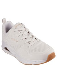 Skechers Sneaker mit einem hellbeigen synthetischen Obermaterial, Schnürverschluss, perforiertem Design und einer Gummisohle mit texturierter Gummilaufsohle.