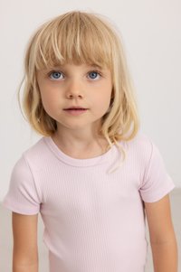 Lichtroze ribbel t-shirt met korte mouwen, ronde halslijn en een zachte textuur. De achtergrond is eenvoudig en neutraal.