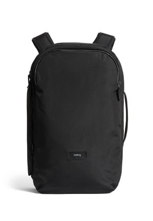 Zaino nero realizzato in tessuto resistente. Presenta spallacci regolabili, un compartimento principale con zip e un logo discreto nella parte inferiore.