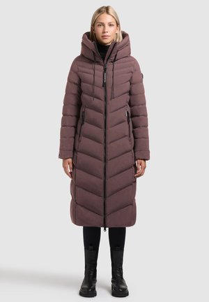 Palton puf lung, cu glugă, de culoare mauve închis, cu un model cusut în zigzag, cu închidere zip în față și buzunare laterale. Asortat cu colanți negri și cizme.
