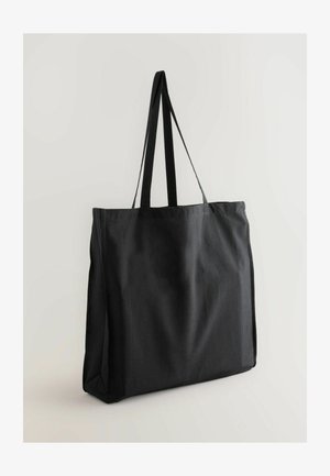 Svart tygkasse med långa axelremmar, rektangulär form, slät yta och utan synliga mönster eller detaljer i metall.