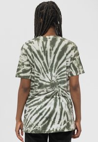 Green and white tie-dye short-sleeve t-shirt with a spiral pattern, made of soft fabric, featuring a relaxed fit and a rounded neckline.