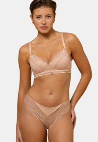 Ensemble soutien-gorge en dentelle et culotte assortie en couleur nude. Le soutien-gorge présente un design en V avec des accents en dentelle et des bretelles ajustables. Texture douce.