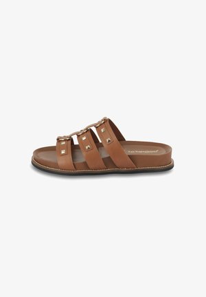 Brown leather slide sandals featuring three wide straps, studded accents, and a flat sole with a stitched edge.