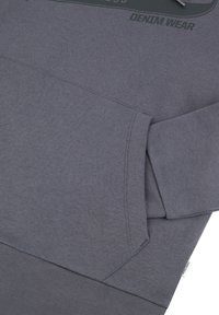 Szary sweatshirt o gładkiej fakturze, z kieszenią typu kangur i ściągaczami przy rękawach. Zawiera nadrukowany wzór graficzny z przodu.