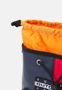 Piikkikassi on tummansinisellä ulkopinnalla, oranssilla sisäpinnalla, mustilla yksityiskohdilla ja logopatchilla. Materiaali vaikuttaa vedenkestävältä.