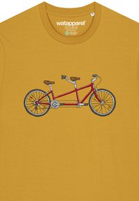 Geel T-shirt met een afbeelding van een rode tandemfiets. De fiets heeft twee bruine zittingen, zilveren handvatten en zwarte wielen met oranje accenten.