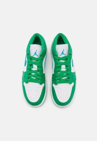 Paire de baskets Nike Air Jordan blanches et vertes avec un swoosh et un logo bleu sarcelle, vues de dessus sur fond blanc.