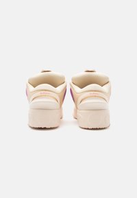 Sneaker beige con dettagli rosa presentano un colletto imbottito e una suola in gomma testurizzata. Il retro mostra dettagli del marchio discreti.