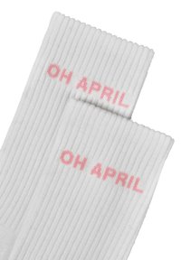 Hvite rillede sokker med teksten "OH APRIL" i rosa skrift. Har en myk tekstur og medium høyde. Passer til avslappet bruk.