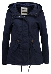 Marineblaue Jacke mit Kapuze, ausgestattet mit Kordelzügen, zwei vorderen Taschen und braunen Akzenten. Hergestellt aus glattem, leichtem Stoff.