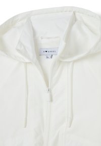 Giacca bianca con cappuccio, dotata di una zip a tutta lunghezza, realizzata in materiale leggero e con un'etichetta che recita "B ♥ ANGEL" all'interno del collo.
