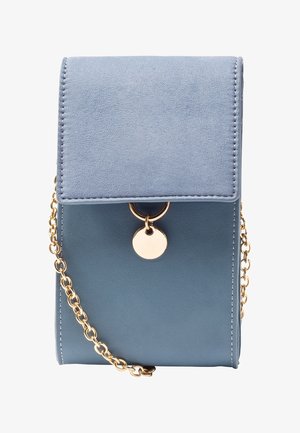 Pequeño bolso azul cruzado con correa de cadena dorada, solapa de ante y cierre circular dorado en la parte delantera.