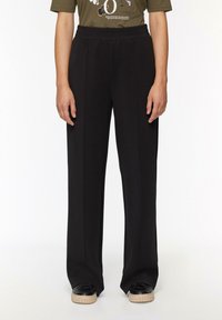 Schwarze weit geschnittene Hose aus weichem Stoff mit einem elastischen Bund. Merkmale ein sauberes Design ohne sichtbare Muster oder Akzente.
