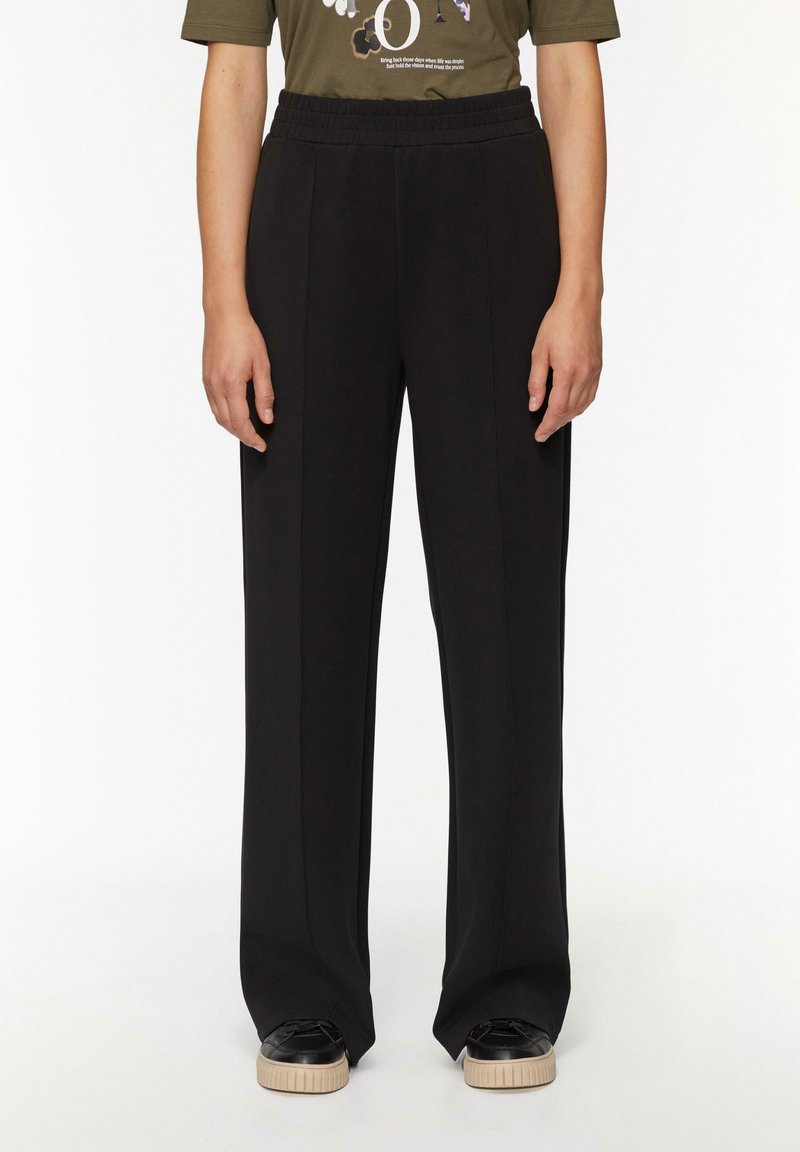 Schwarze weit geschnittene Hose aus weichem Stoff mit einem elastischen Bund. Merkmale ein sauberes Design ohne sichtbare Muster oder Akzente.