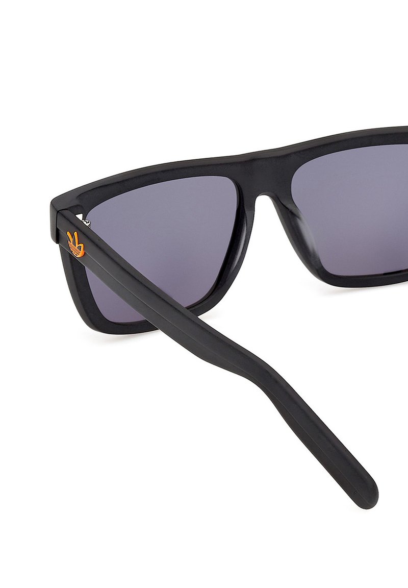 Gafas de sol rectangulares negras con lentes oscuras y un logo de mano haciendo el signo de la paz en color naranja en la patilla izquierda.