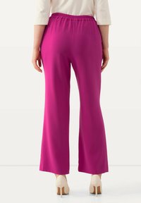 Fuchsiové široké kalhoty s elastickým pasem, hladkým povrchem a draped designem, doplněné béžovými lodičkami.