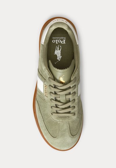 Alyvuogių žalia zomšinė sportinė avalynė su balta juostele, rudu padu, raišteliais ir auksiniu Polo Ralph Lauren logotipu ant liežuvėlio ir šono.