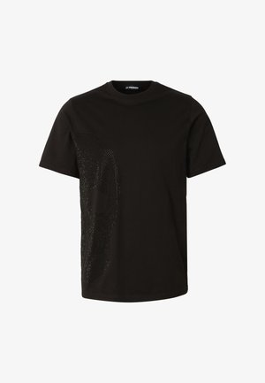 Tricou negru cu mânecă scurtă, cu un design subtil de craniu cu pietre strălucitoare pe partea stângă și cu gât rotund.