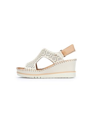 Sandalia cuña blanca perforada con diseño recortado y acento beige. Presenta una correa en el talón y suela texturizada para mayor agarre. Elegante y transpirable.