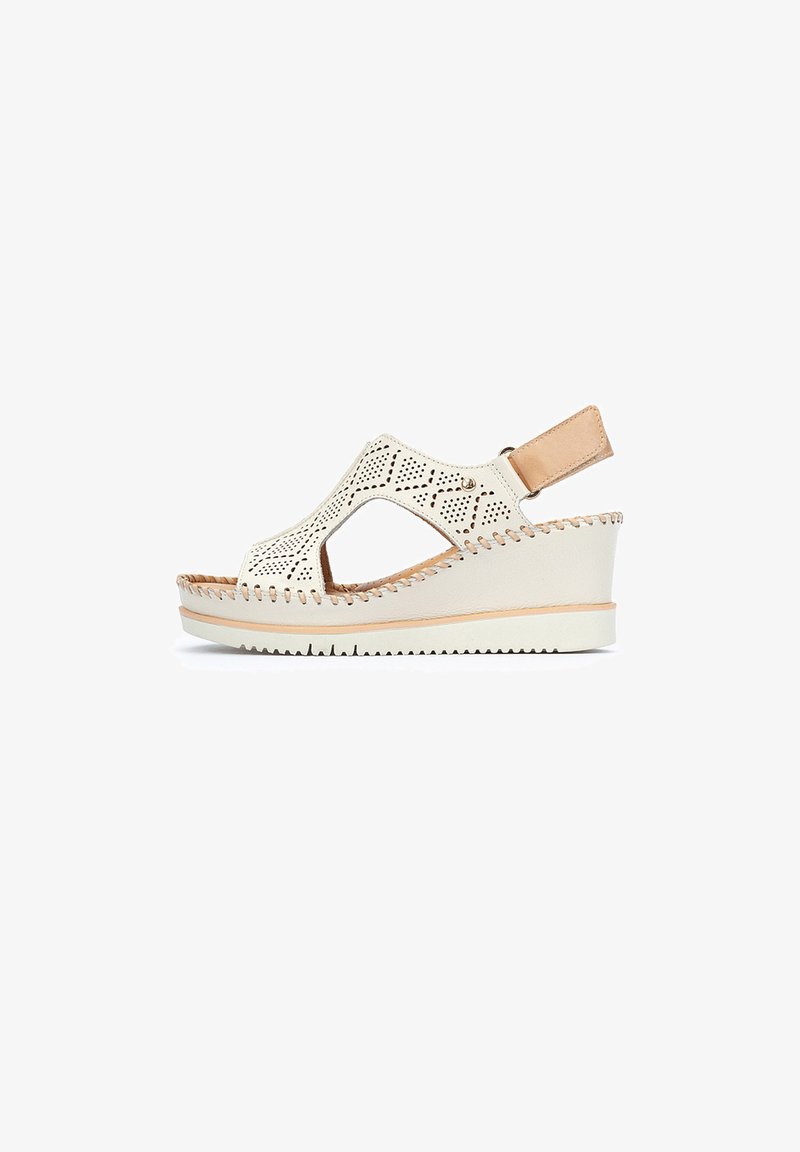 White perforated wedge sandal with cut-out design and beige accent. Features a heel strap and textured sole for grip. Elegant and breathable.
