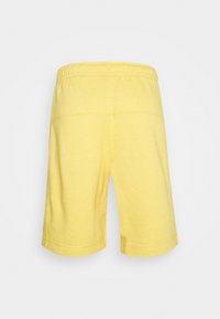 Shorts en coton jaunes avec une coupe décontractée, dotés d'une taille élastiquée, d'une longueur au genou et de simples détails de couture.