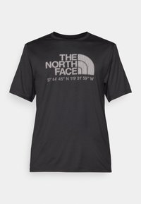T-shirt noir à manches courtes en tissu léger, avec un graphique comportant un texte et un logo en blanc, indiquant des coordonnées sous le logo.