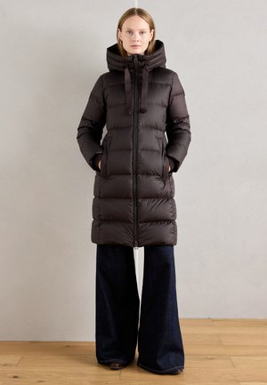 Bruine pufferjas met een capuchon en ritssluiting, voorzien van horizontale quiltstructuur en een relaxte fit, gecombineerd met wijde denim broek.