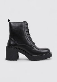 Bottine en cuir noir avec un talon épais, un laçage à l'avant et une semelle en caoutchouc texturé pour une meilleure adhérence. Fini lisse et conception robuste.