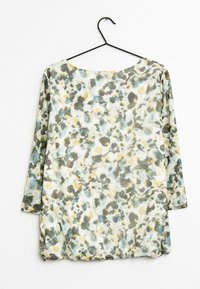 Blouse légère à motif floral avec une coupe ample, dotée d'un col rond et de manches trois quarts dans des tons de bleu, gris et jaune.