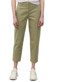 Olijfgroene broeken van katoen, met een rechte pijp en een cropped lengte, gecombineerd met witte sneakers.