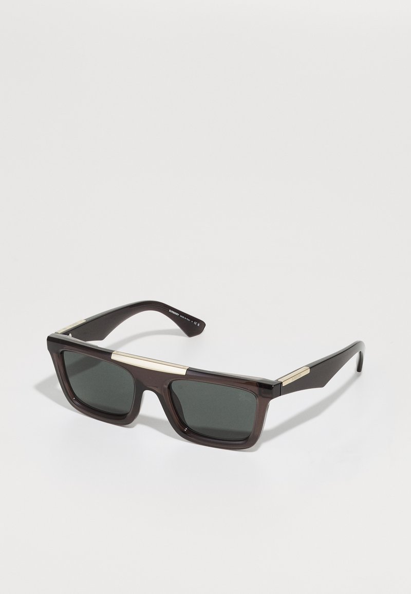 Ochelari de soare din plastic brown cu lentile întunecate, de formă pătrată, și accente din metal auriu pe punte și pe tâmple.