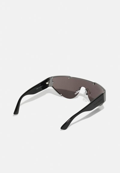 Occhiali da sole neri con un design elegante e angolare, lenti grigie oscurate e dettagli metallici. Presentano una montatura leggera e un logo sul braccio.