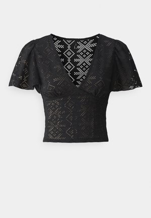 Black short-sleeve blouse with a deep V-neck, featuring a patterned mesh fabric and a fitted silhouette. Accented with puffed sleeves.