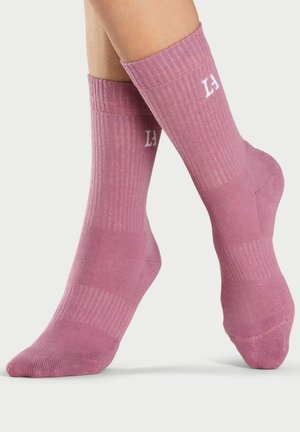 Pink ribbed socks featuring a white logo, mid-calf length, and a smooth texture with contrasting stripes.
