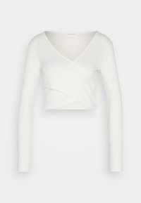 Weißes Langarm-Wickeloberteil aus geribtem Material mit V-Ausschnitt und einer taillierten Silhouette, das ein überlappendes Frontdesign aufweist.