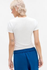 Vit, figursydd t-shirt med korta ärmar, slät textur och klassisk rundhalsdesign. Bärs med blå shorts med elastisk midja, minimala detaljer.