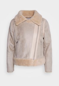 Beige bunda ve stylu ovčí vlny s širokým huňatým límcem, diagonálním zipem, kapsami na zip a huňatými lemy na spodním okraji a na manžetách.