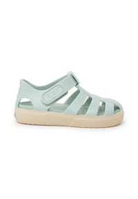 Light green rubber sandal with open design, adjustable strap, and textured sole. Features a cream-colored sole for added contrast.